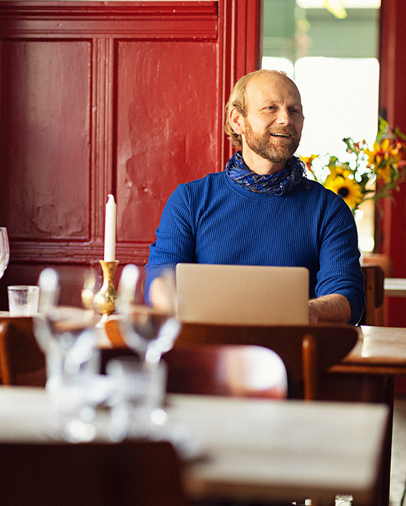 En mand sidder ved sin computer på en restaurant