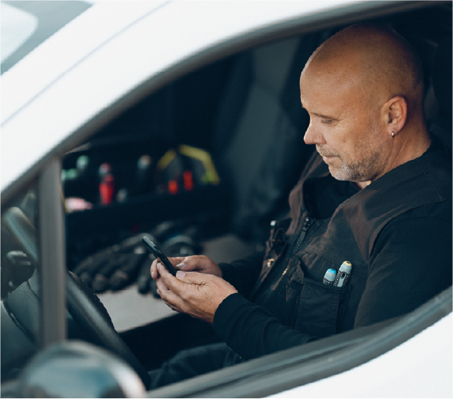 mand med telefon i hånd i bil