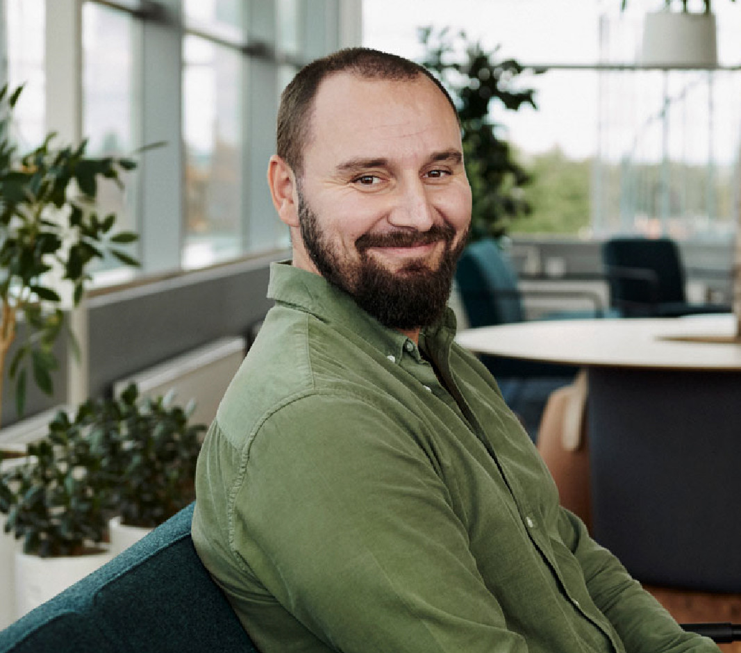 mand der sidder på kontor og smiler 
