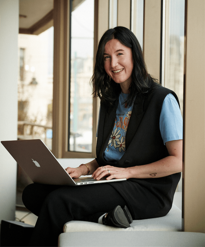 dame sidder i vindueskarm med laptop og digitaliserer sine bilag i e-conomic programmet
