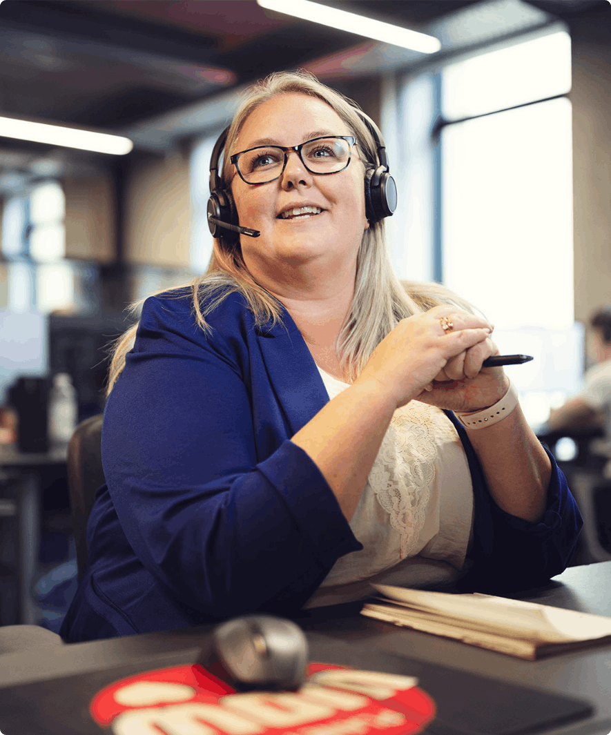 Et portrætbillede af en kvinde, der sidder med headset på