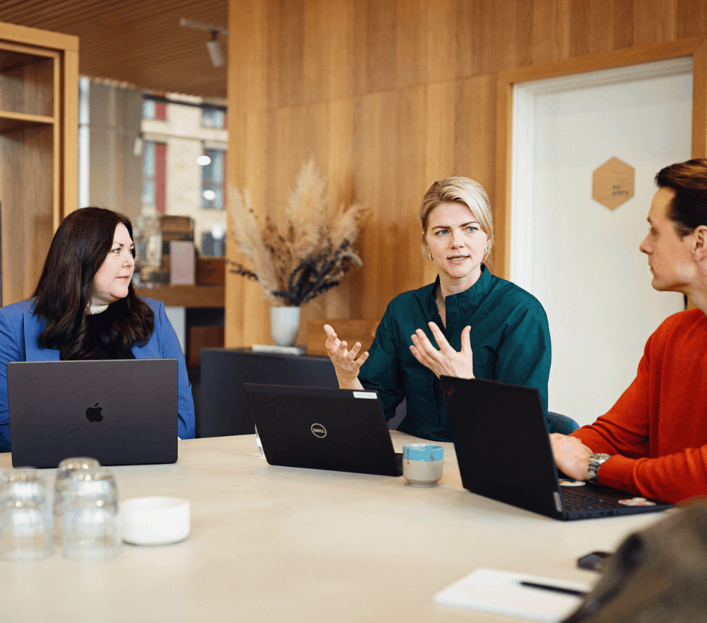 Tre mennesker sidder og har møde
