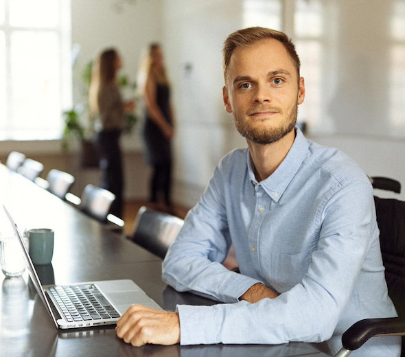 En mand sidder ved en computer og arbejder med regnskab