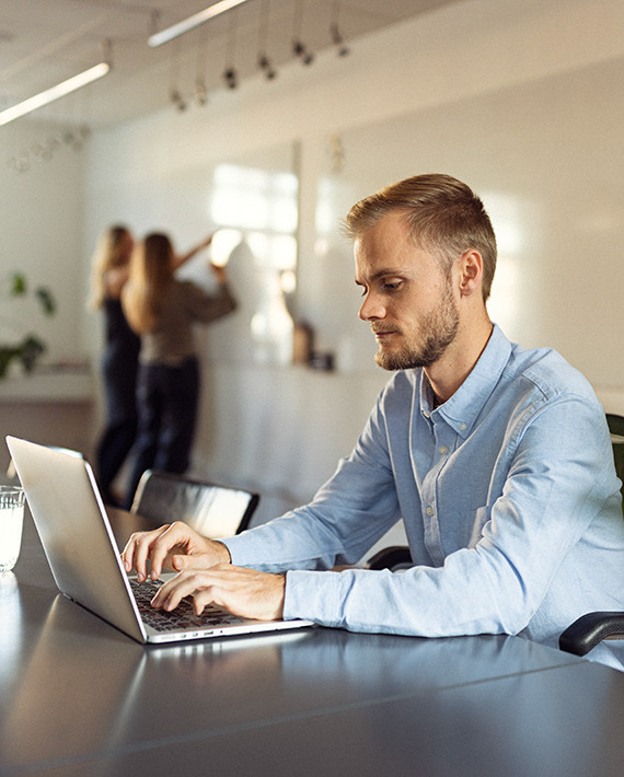 En mand sidder og kigger på sin computer