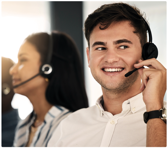 En mand snakker i headset, mens han smiler og kigger ud i luften