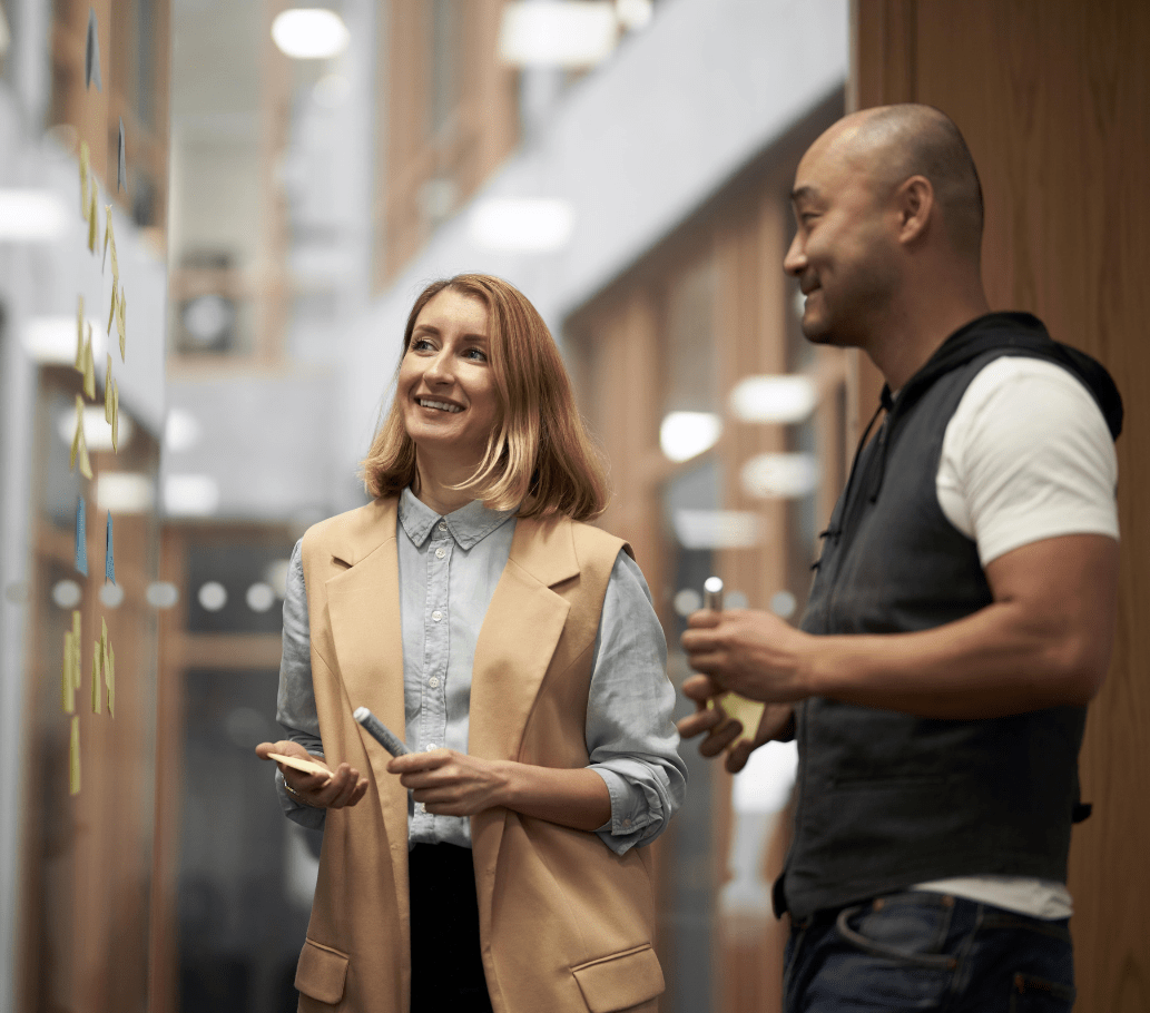 To mennesker står og kigger på et vindue med post-its