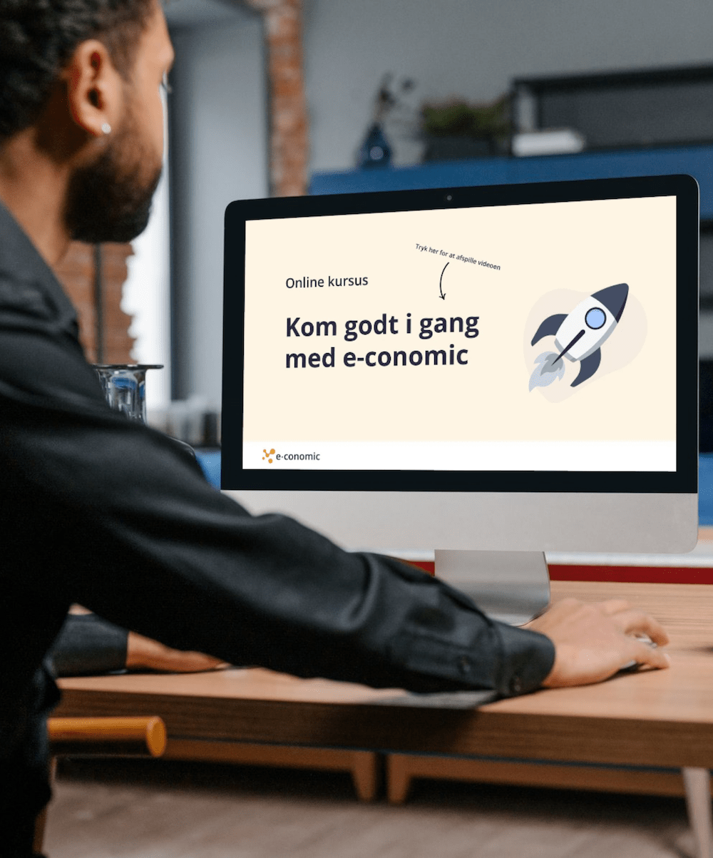 En mand sidder ved en computer og ser en video