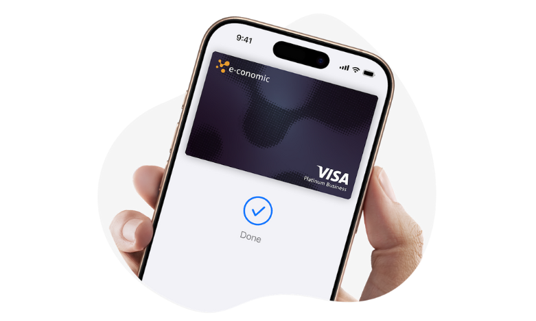 En hånd, der holder en smartphone med et kreditkort på skærmen