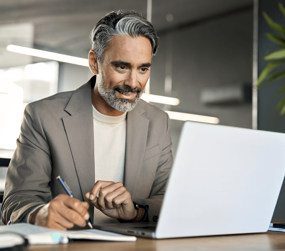 Mand skriver og kigger på computer
