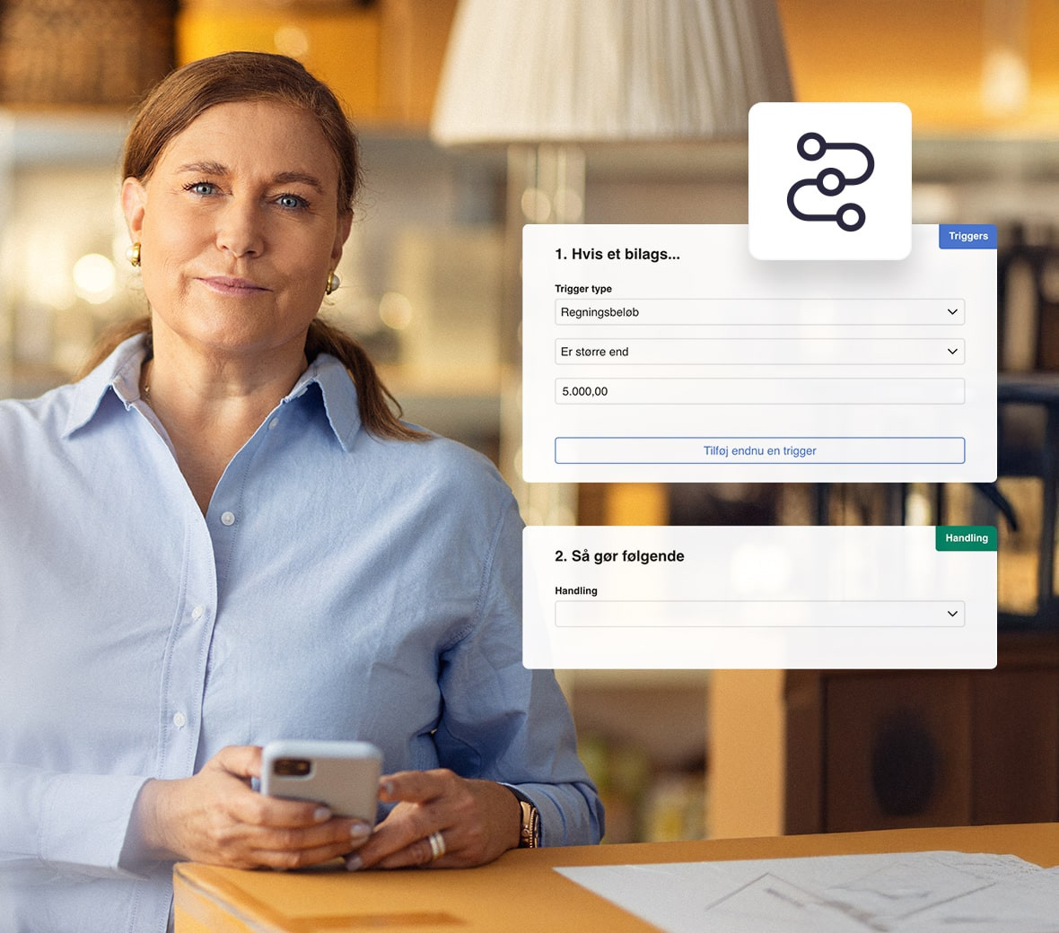 En kvinde står med en smartphone i hånden og smiler til kameraet