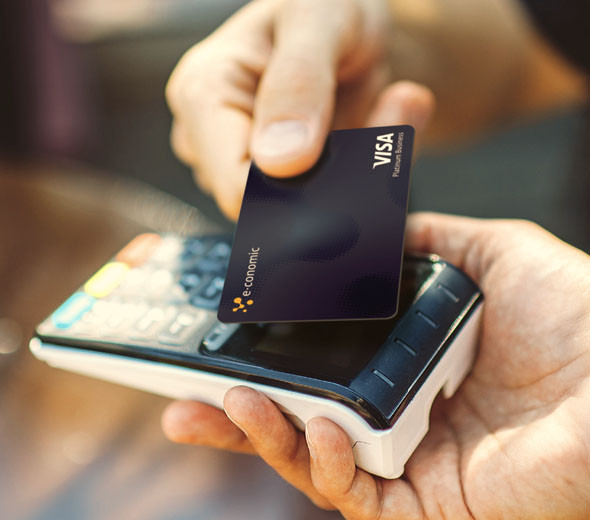 Et billede af e-conomics Firmakort, der holdes over en terminal