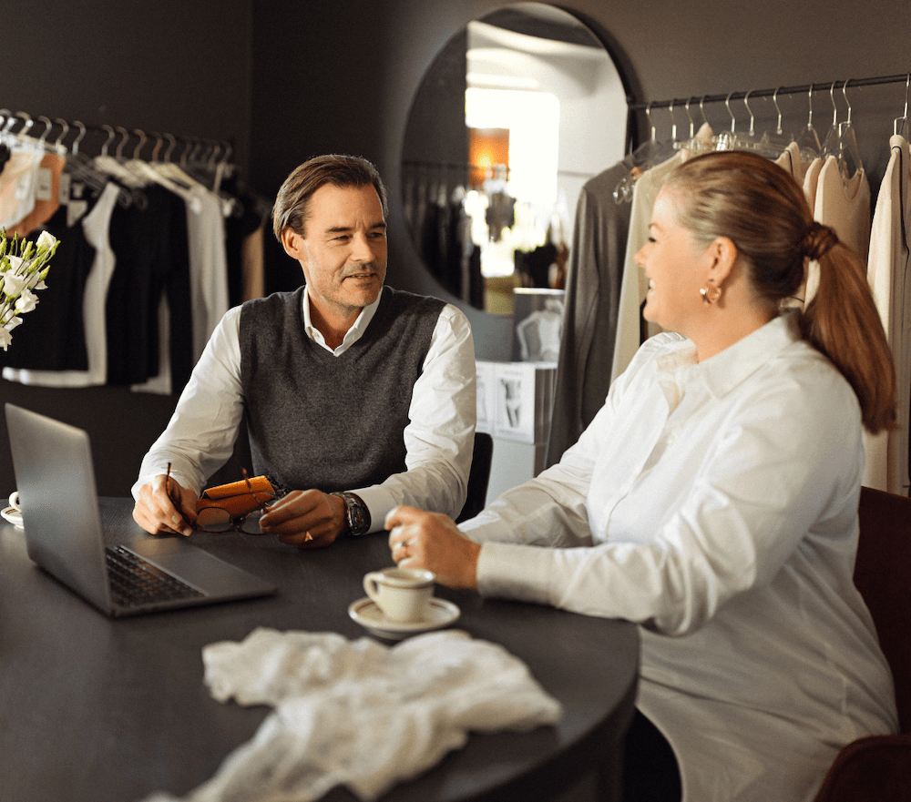 To mennesker sidder sammen i en butik og snakker sammen