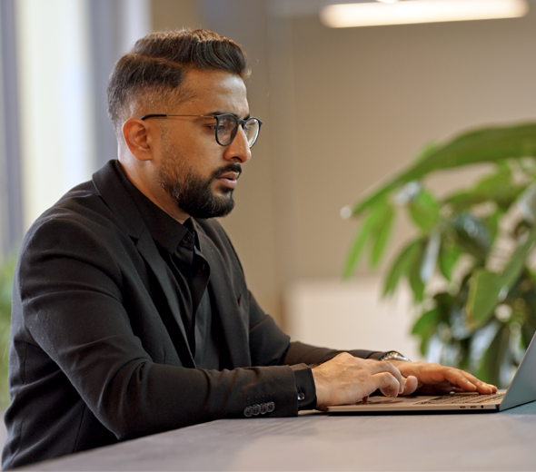 En mand sidder og kigger på en computer