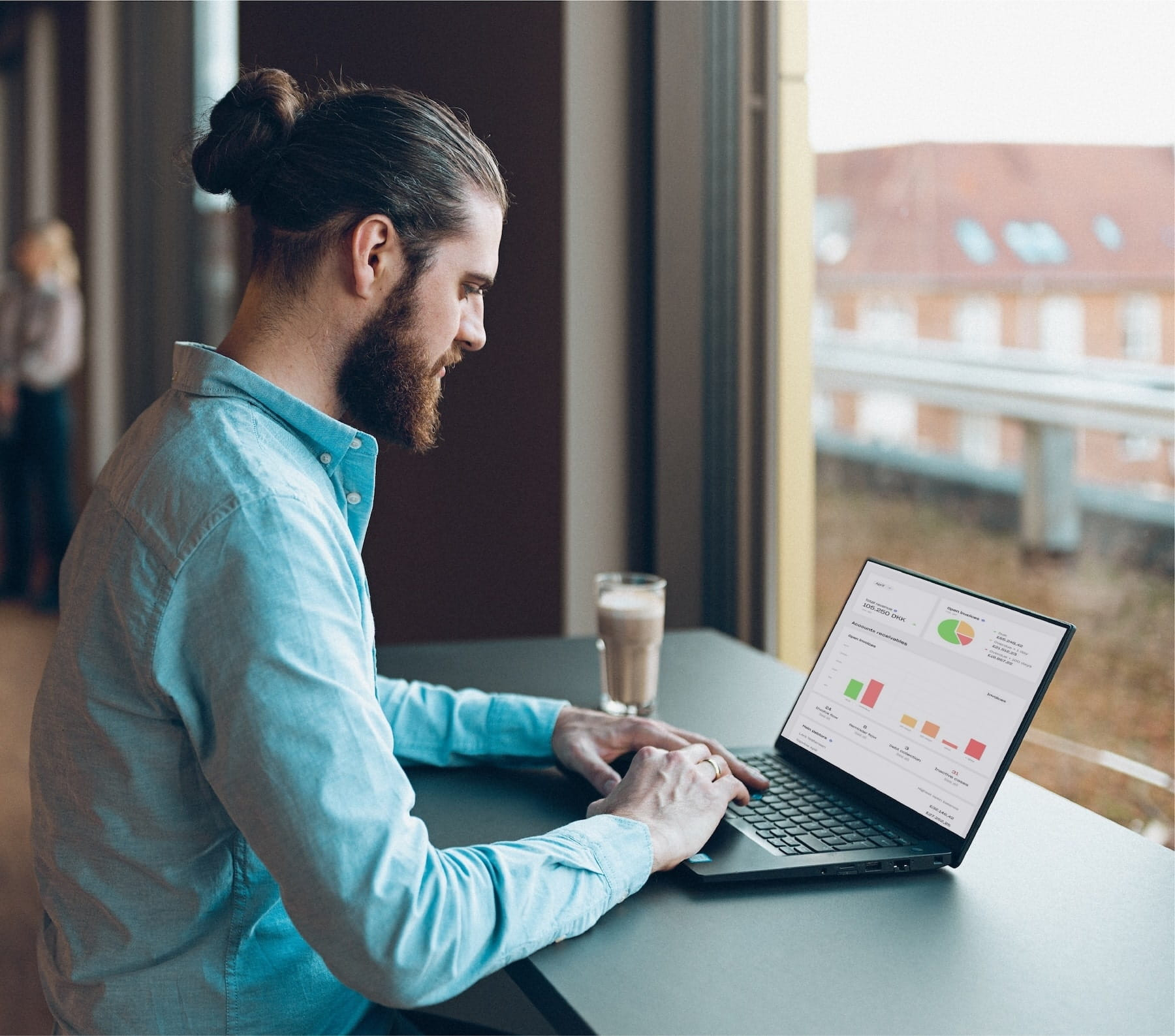 En man sidder og kigger på en computer, hvor der er flere forskellige diagrammer på skærmen