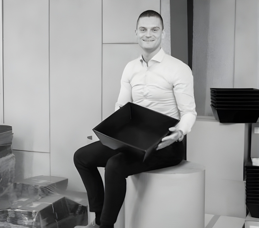 Et billede af en mand, der sidder med en kasse i skødet